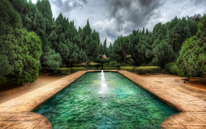 Rectangular fountain with trees and cloudy sky