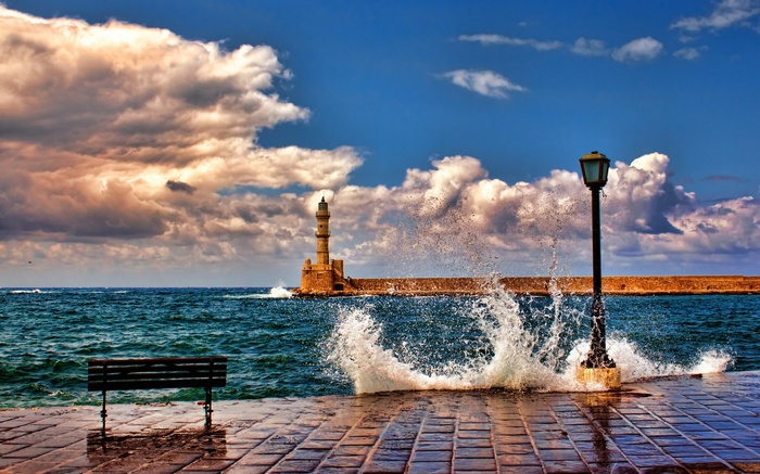 Lighthouse on a pier with waves crashing