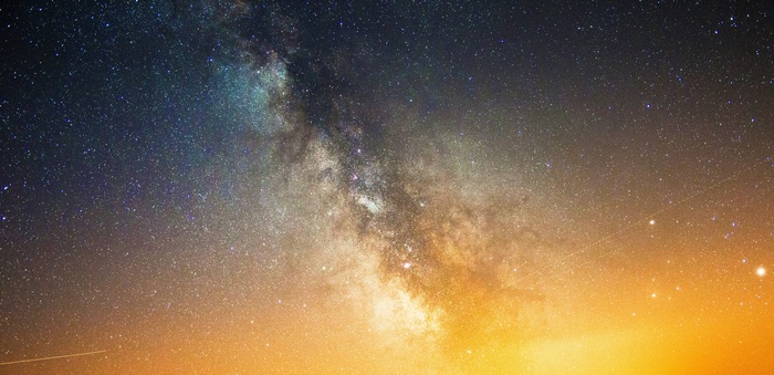 Milky Way galaxy with stars and orange glow
