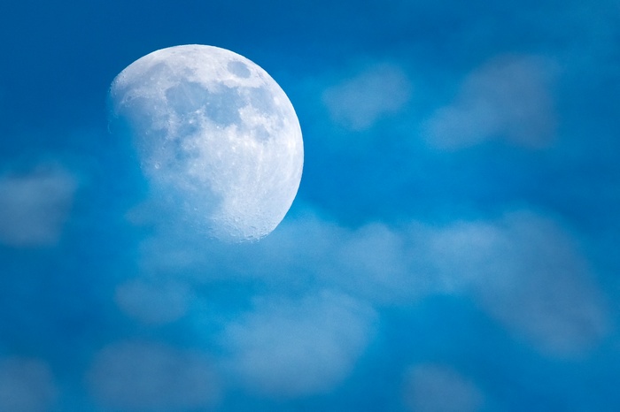 Half moon in blue sky with clouds