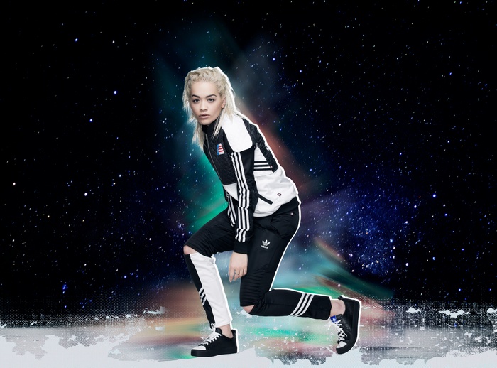 Rita Ora in Adidas tracksuit against starry background