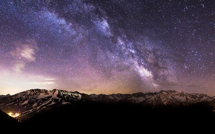 Milky Way over snow-capped mountains at night