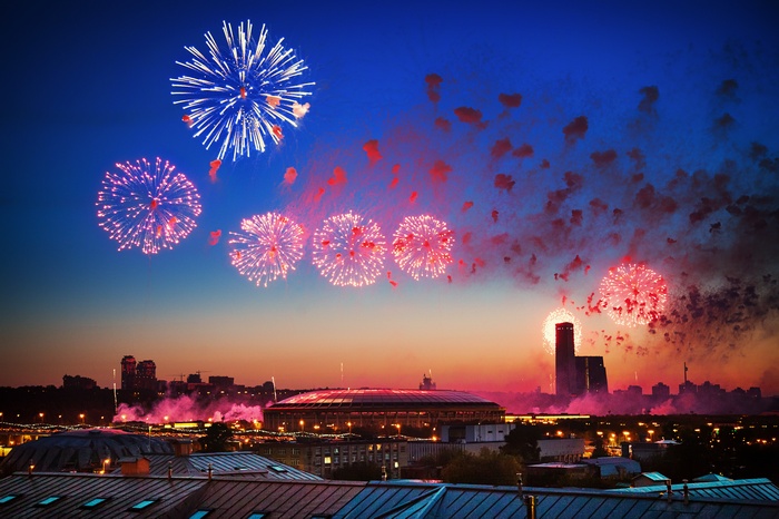 Fireworks over a city at dusk