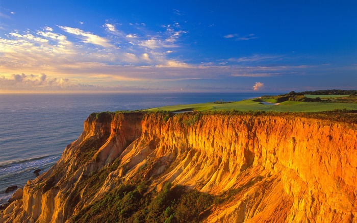 Golden cliffs overlooking the ocean with a golf course