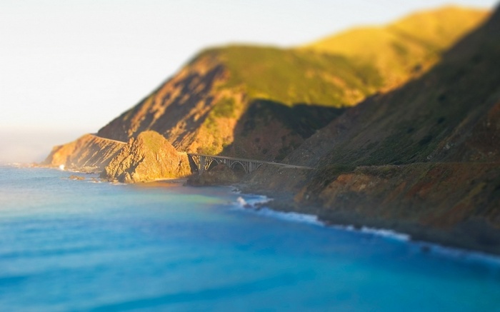 Bridge over the ocean near a mountain
