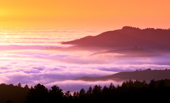 Sunset over misty hills and clouds
