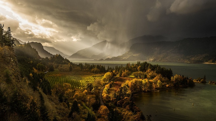 Stormy sky over a river valley with autumn trees