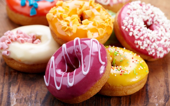 Assortment of colorful donuts on a wooden surface