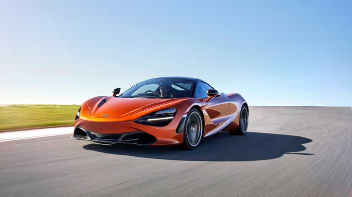 Orange McLaren 720S Coupe driving on a road