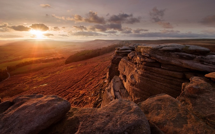 Sunset over rocky cliffs and heather moorland