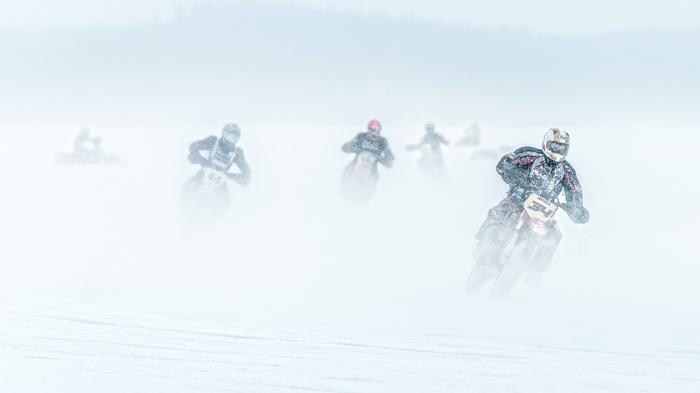 Motorcyclists racing on a snowy track