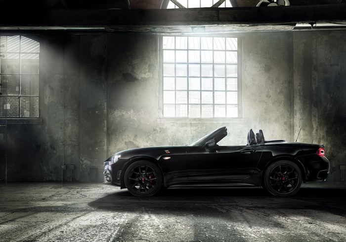 Black Abarth 124 Spider Scorpione convertible in a warehouse