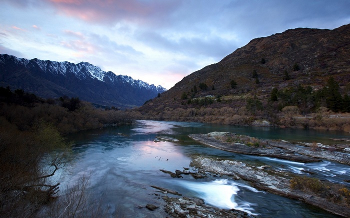 River flowing through mountains at dusk
