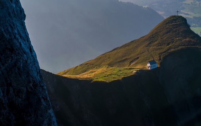 Chapel on a mountain peak with a cross