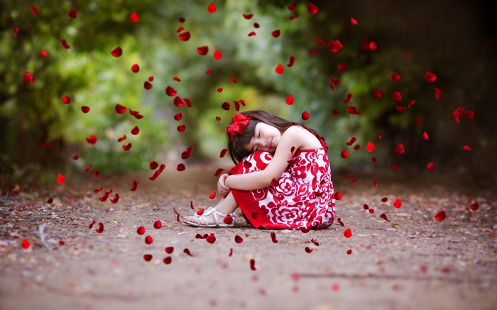 Girl in red dress with rose petals