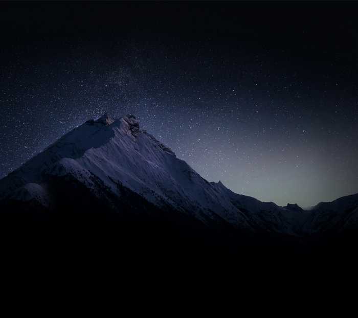 Snowy mountains under a starry night sky