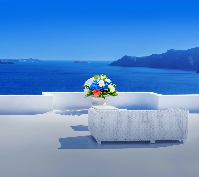 White Wicker Sofa and Flower Vase on Balcony with Sea View