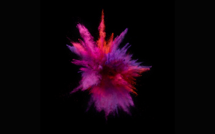 Explosion of pink and red powder on black background