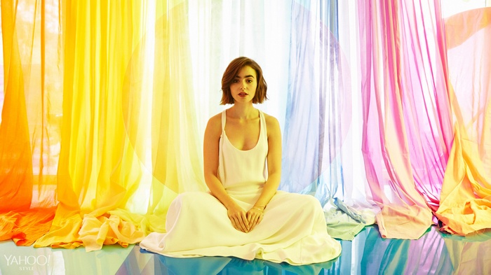 Lily Collins sitting in front of rainbow curtains