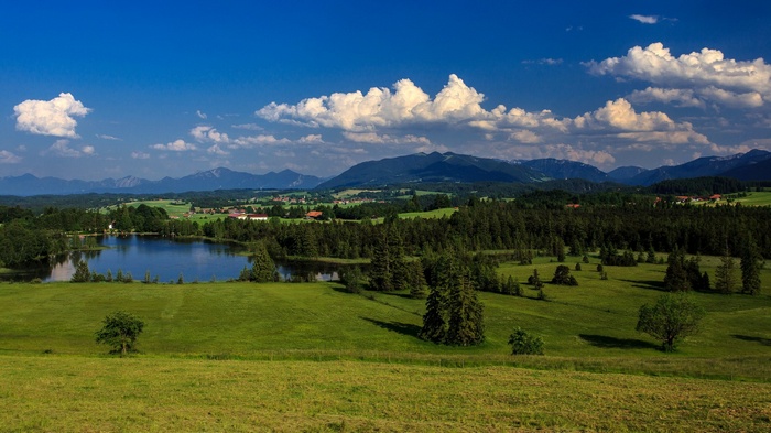 Green rolling hills with a lake and mountains
