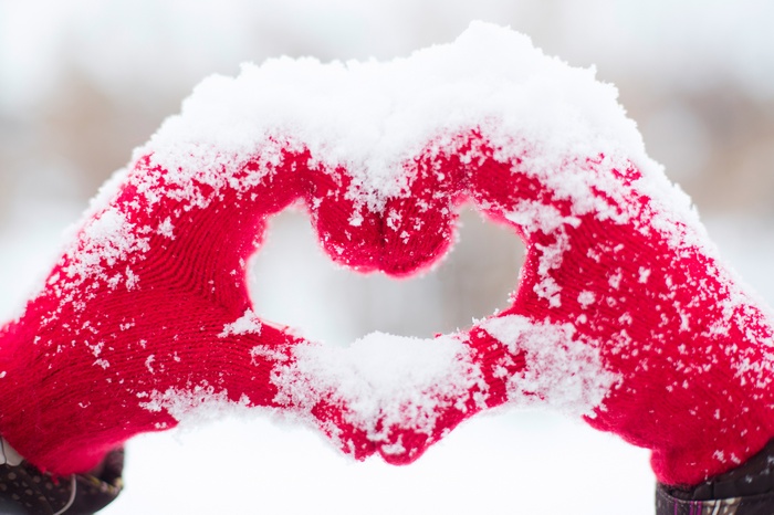 Hands forming a heart shape in the snow