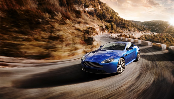 Blue Aston Martin V8 Vantage S on a winding mountain road