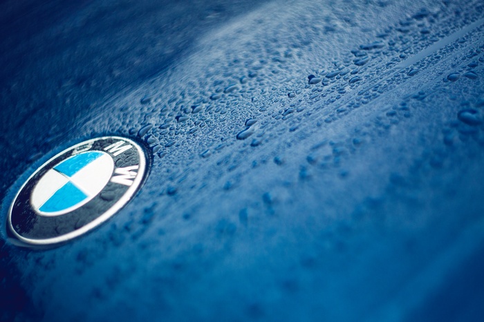 BMW Logo on a Wet Blue Car Hood