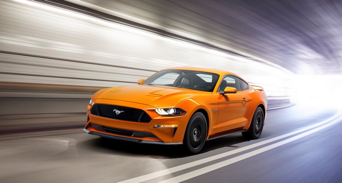 Orange Ford Mustang GT driving through a tunnel