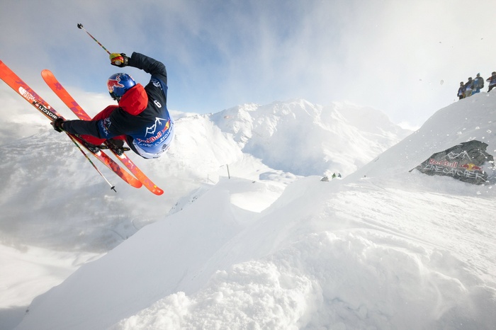 Red Bull athlete performing a ski jump in the mountains