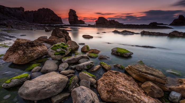 Rocky coastline at sunset with calm water