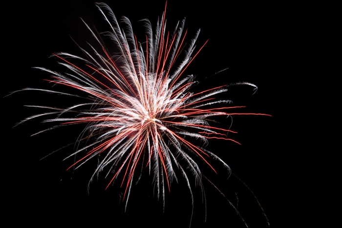 Red and white fireworks exploding in the night sky