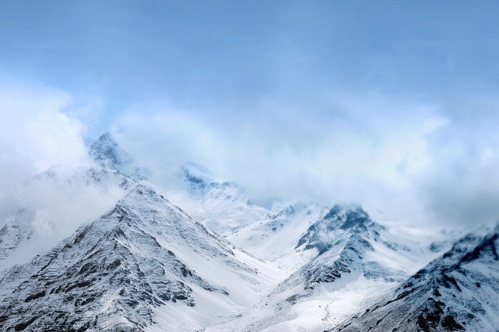 Snow-covered mountains under a cloudy sky