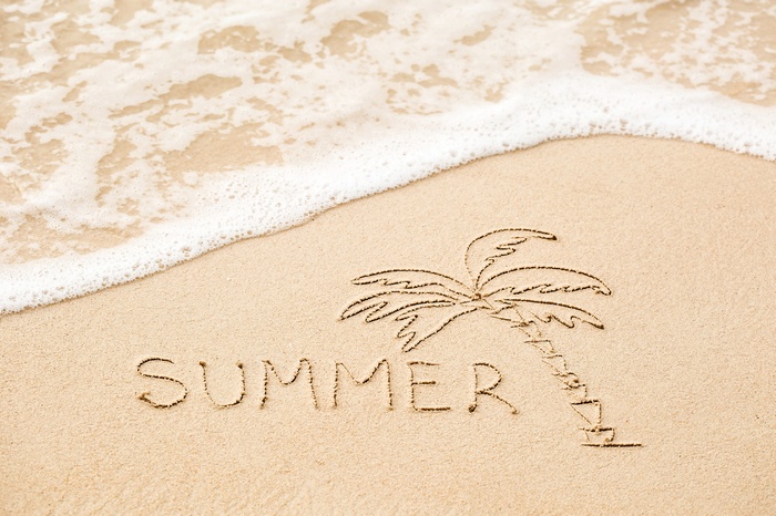 Summer written in sand with a palm tree drawing