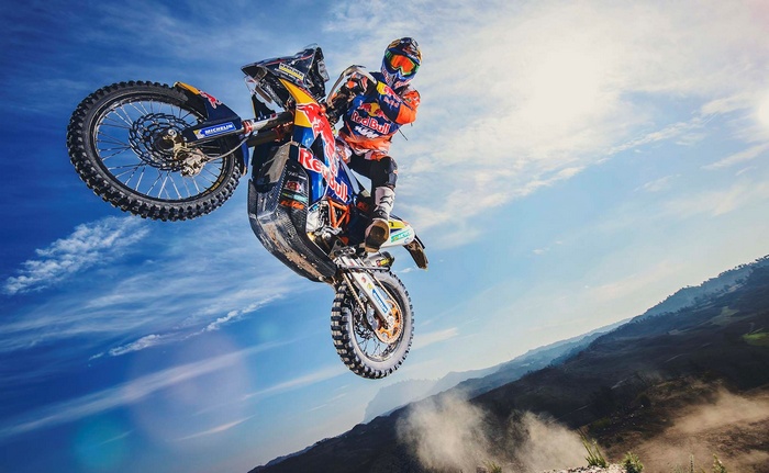 KTM 450 Rally rider performing a stunt jump