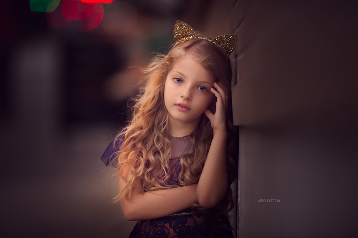 Young girl with blonde curly hair and cat ears