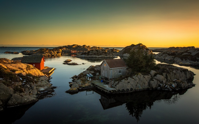 Rocky shore with houses at sunset