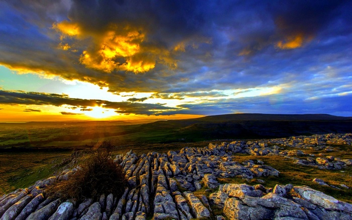Sunset over rocky landscape with dramatic clouds