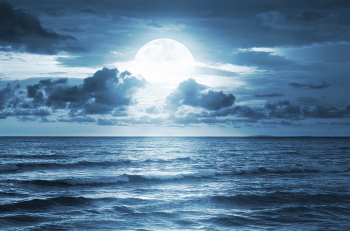 Full moon over the ocean with clouds