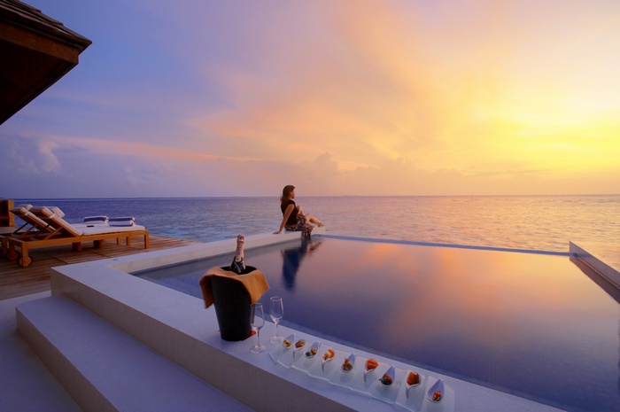 Luxury hotel swimming pool at sunset with champagne