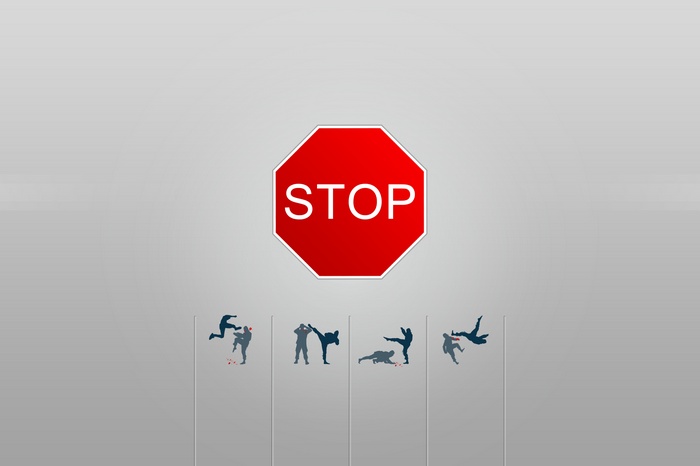 Stop sign above martial arts silhouettes