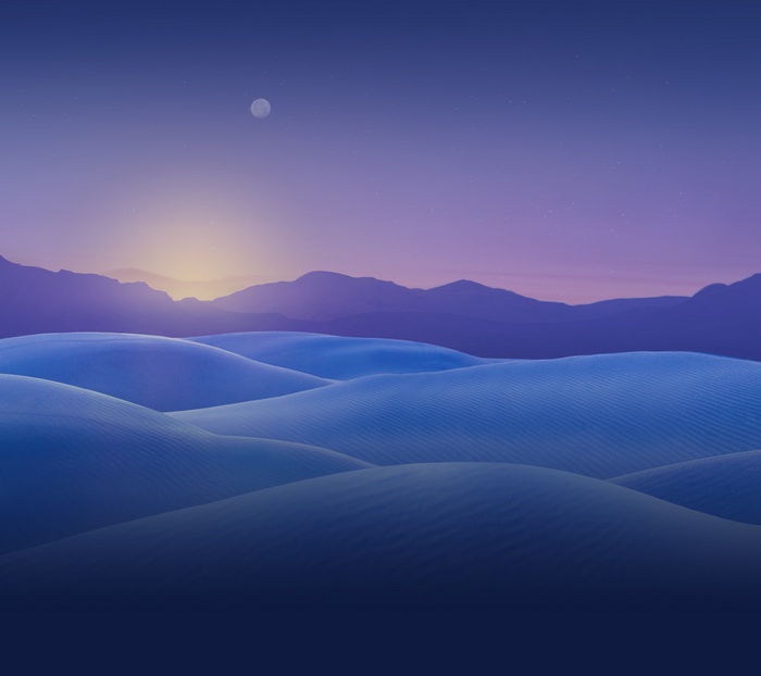 Desert sand dunes at sunset with mountains and moon