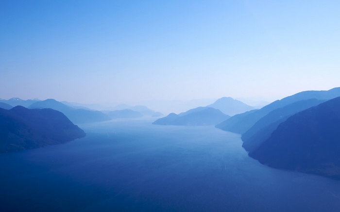 Misty mountains and a wide river at dawn