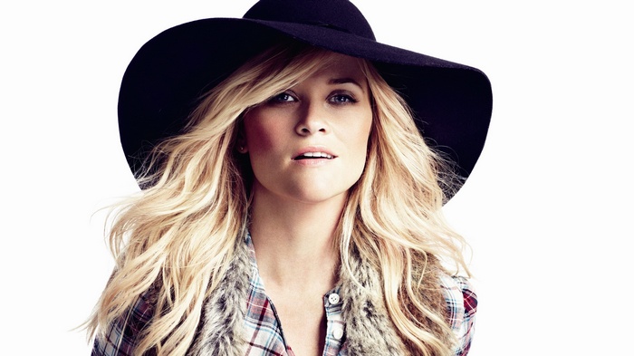 Reese Witherspoon wearing a black hat and fur vest