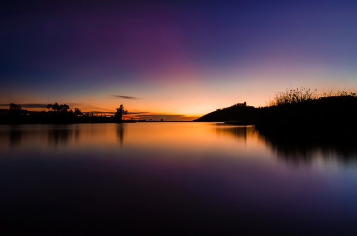 Lake at Dusk with Silhouetted Hills