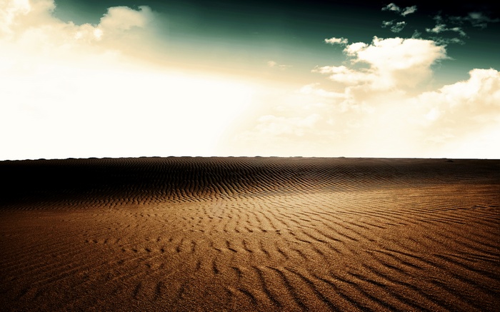 Desert landscape with sand dunes and clouds