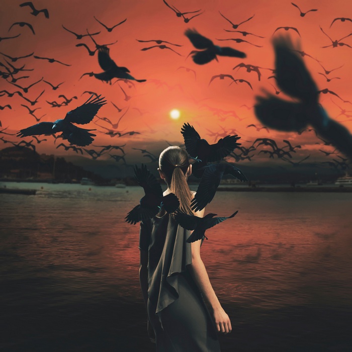Girl surrounded by birds at sunset