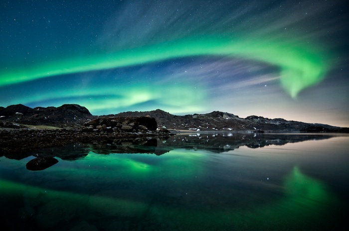Aurora Borealis over Iceland landscape with lake reflection