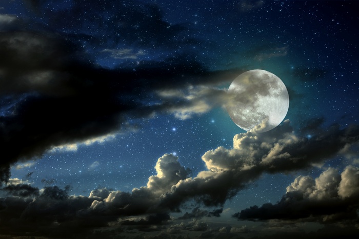 Full moon and stars behind clouds