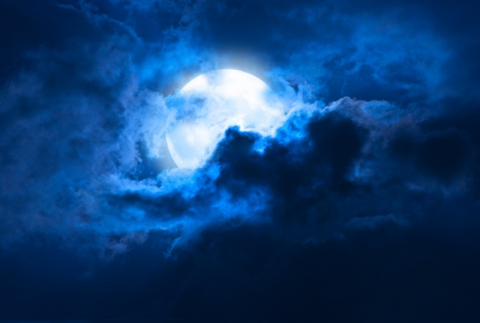 Full moon behind dark clouds
