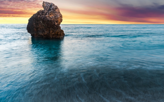 Lone rock in the sea at sunset, Milos Beach, Greece, 4K